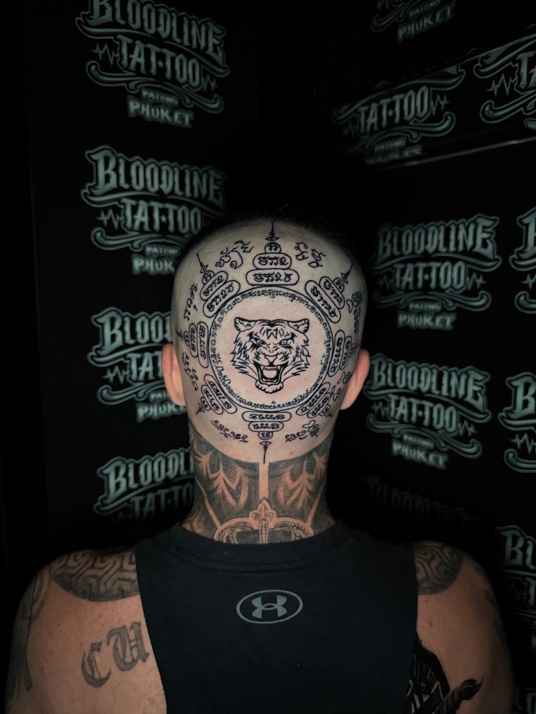 Yant Suea tiger-head Sak Yant with concentric Khom script rings and unalomes on the back of the head at Bloodline Tattoo Phuket.
