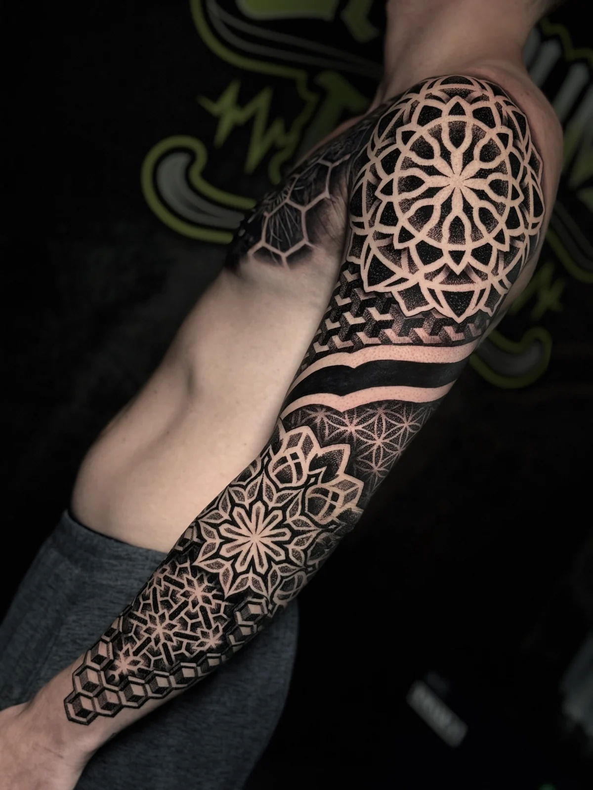 Full mandala sleeve with shoulder and forearm lotus mandalas, Flower of Life bands, and 3D cube dotwork near the wrist at Bloodline Tattoo Phuket.